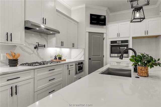 kitchen with light stone countertops, stainless steel appliances, pendant lighting, decorative backsplash, and white cabinets