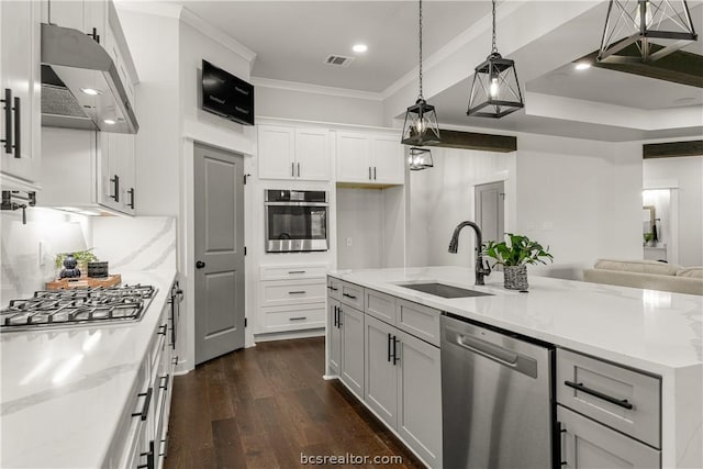 kitchen featuring light stone countertops, appliances with stainless steel finishes, sink, decorative light fixtures, and white cabinets