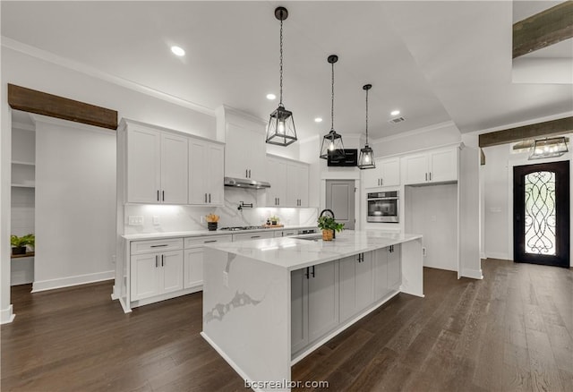 kitchen featuring light stone counters, dark hardwood / wood-style flooring, oven, a spacious island, and white cabinets