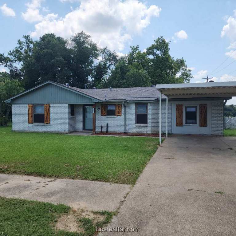 ranch-style house with a carport and a front lawn