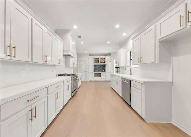 kitchen featuring backsplash, recessed lighting, light wood-style floors, white cabinets, and stainless steel appliances