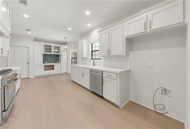 kitchen featuring decorative backsplash, white cabinets, stainless steel appliances, and visible vents