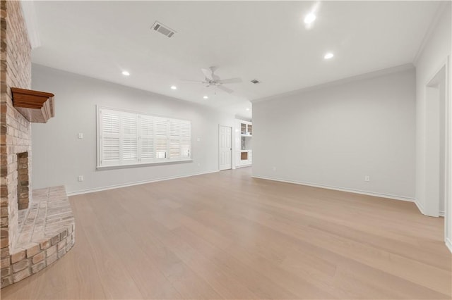 unfurnished living room with light wood finished floors, visible vents, a brick fireplace, and a ceiling fan