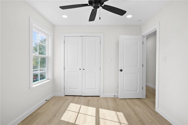 unfurnished bedroom featuring ceiling fan, light wood-type flooring, and a closet