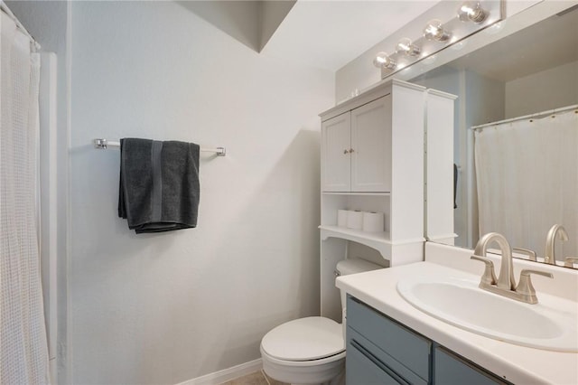 bathroom featuring baseboards, toilet, and vanity