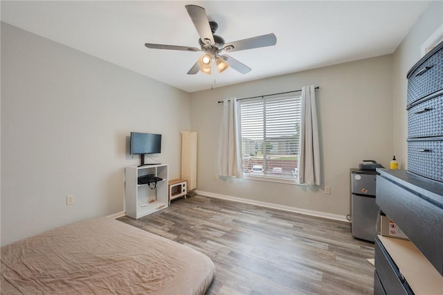 bedroom with ceiling fan, baseboards, and light wood-style flooring