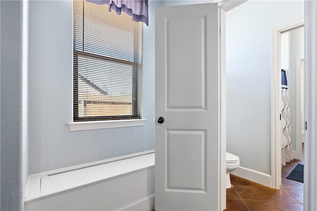 bathroom featuring tile patterned floors, toilet, and baseboards