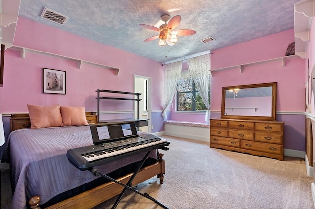 bedroom with visible vents, carpet flooring, a textured ceiling, and baseboards