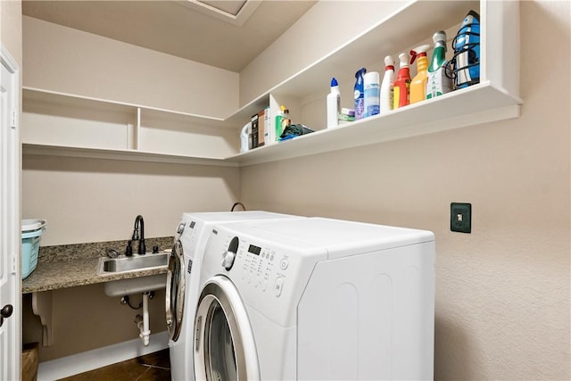 washroom featuring a sink, separate washer and dryer, laundry area, and dark tile patterned flooring