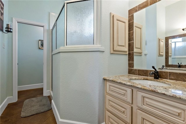 full bathroom featuring an enclosed shower, baseboards, vanity, and tile patterned flooring