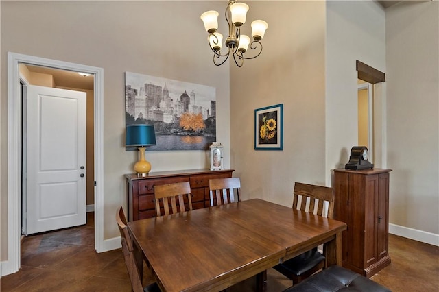 dining space with a chandelier, baseboards, and dark tile patterned flooring