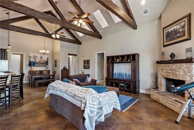 living room with visible vents, beam ceiling, ceiling fan with notable chandelier, a stone fireplace, and baseboards