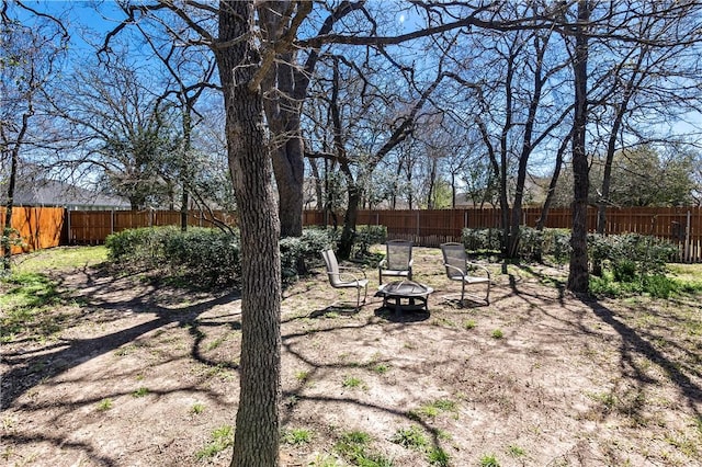 view of yard featuring a fenced backyard and an outdoor fire pit