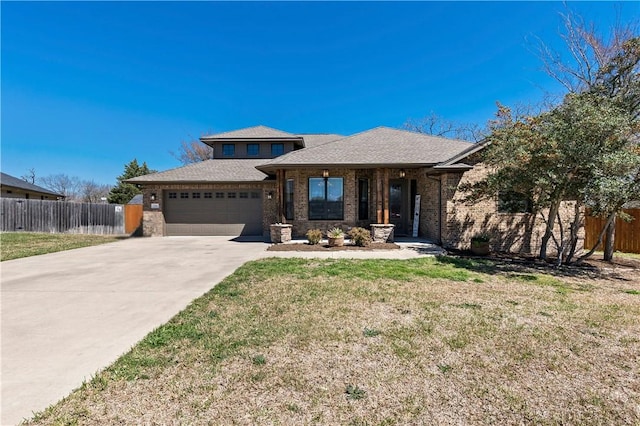 view of front of house with brick siding, concrete driveway, an attached garage, and fence