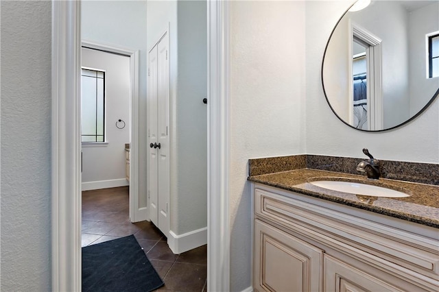 bathroom with tile patterned flooring, vanity, and baseboards