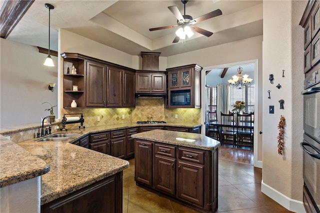 kitchen featuring black appliances, a sink, a tray ceiling, decorative backsplash, and dark brown cabinets