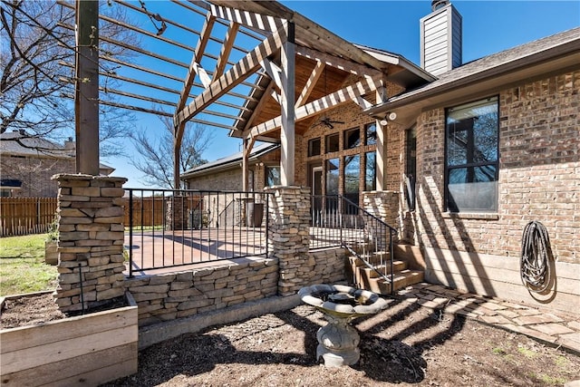 view of home's exterior featuring brick siding, fence, a pergola, and ceiling fan