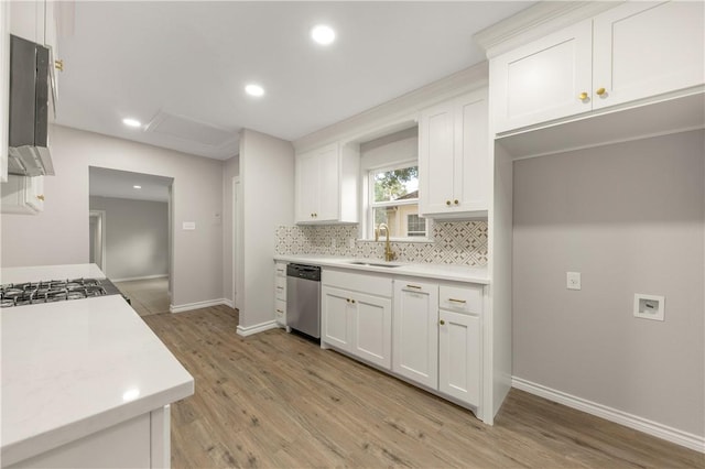 kitchen featuring dishwasher, sink, white cabinets, and backsplash