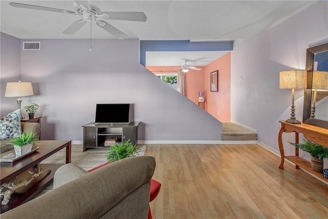 living room with ceiling fan and light hardwood / wood-style flooring