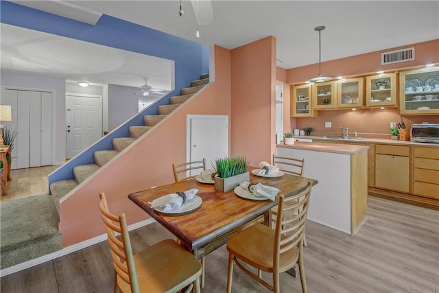 dining space featuring ceiling fan, light hardwood / wood-style flooring, and sink