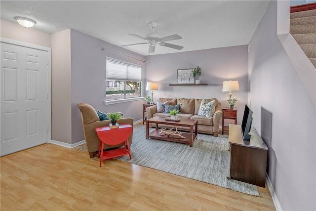 living room with wood-type flooring and ceiling fan