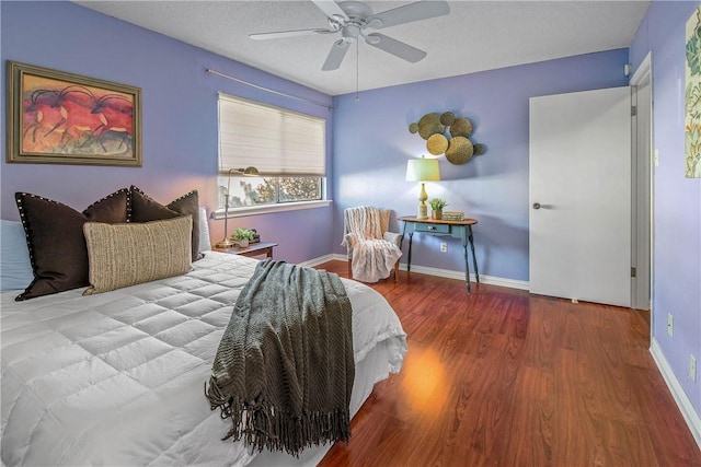 bedroom with ceiling fan, wood-type flooring, and a textured ceiling