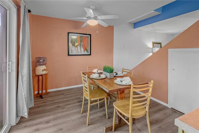 dining area with ceiling fan and light wood-type flooring