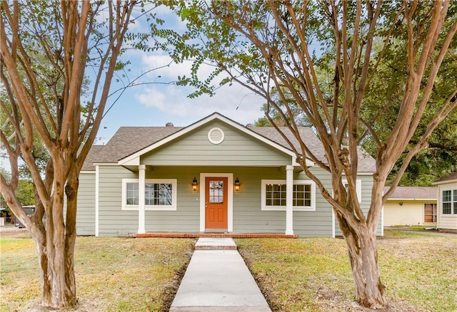 bungalow-style house with a front yard and covered porch