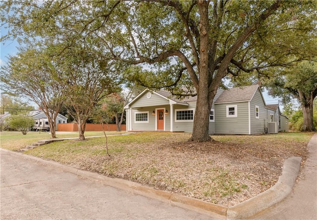 view of front of home with covered porch, a front lawn, and central AC unit