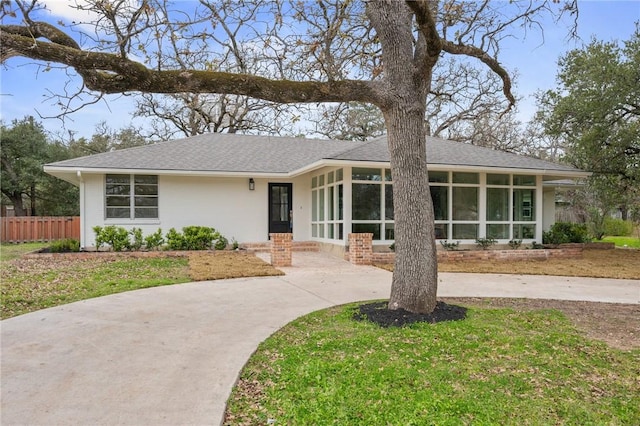 ranch-style house featuring a front lawn and a sunroom