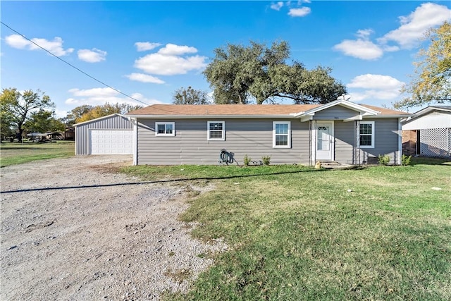 view of front of house featuring a garage, an outdoor structure, and a front yard