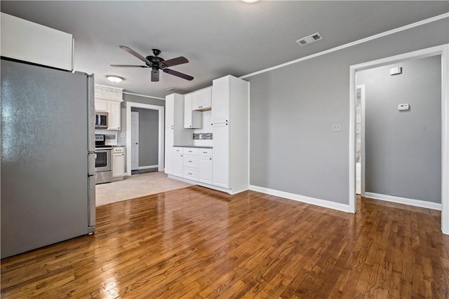 unfurnished living room featuring ceiling fan, ornamental molding, and hardwood / wood-style floors