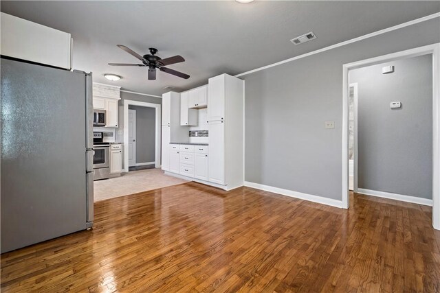 915 E Hanna St, Calvert, TX 77837 - unfurnished living room with ceiling fan, wood finished floors, baseboards, and ornamental molding