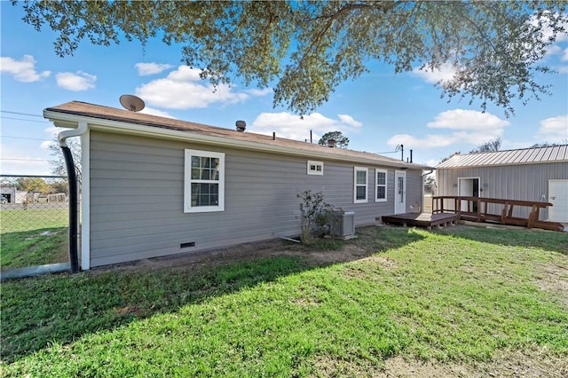 back of house featuring central AC unit, a lawn, and a deck