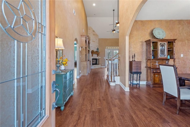 entryway featuring dark wood-type flooring, ceiling fan, and high vaulted ceiling