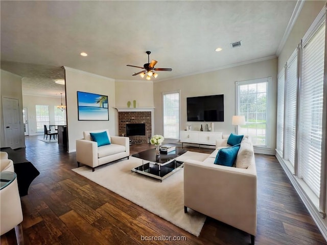 living room with ornamental molding, dark hardwood / wood-style floors, a brick fireplace, and plenty of natural light