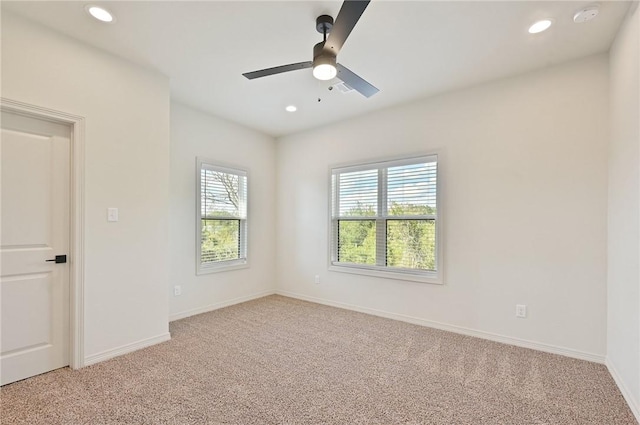 spare room featuring a wealth of natural light, ceiling fan, and light colored carpet