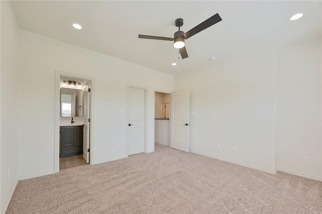 unfurnished bedroom with connected bathroom, ceiling fan, sink, and light colored carpet