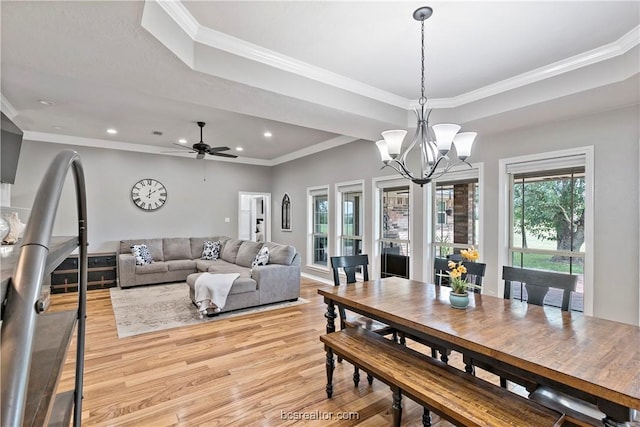 dining area with ceiling fan with notable chandelier, crown molding, and light hardwood / wood-style flooring