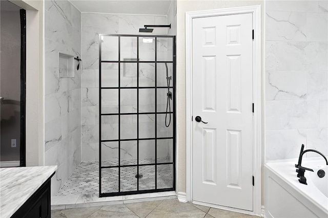 full bathroom featuring walk in shower, a bath, tile patterned floors, and tile walls