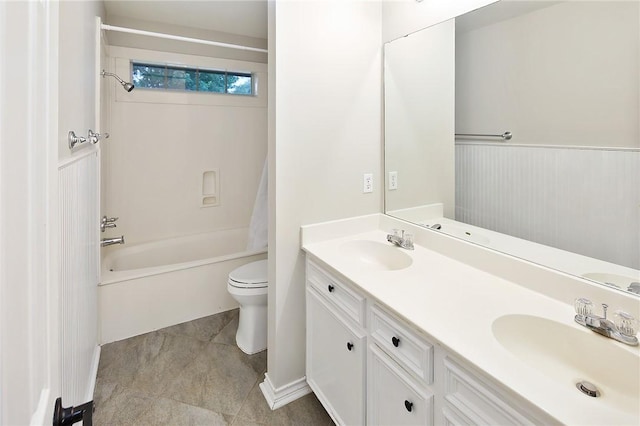 bathroom with toilet, double vanity, and tub / shower combination