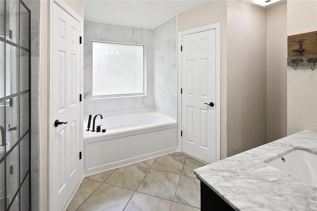 bathroom with vanity, a garden tub, and tile patterned flooring