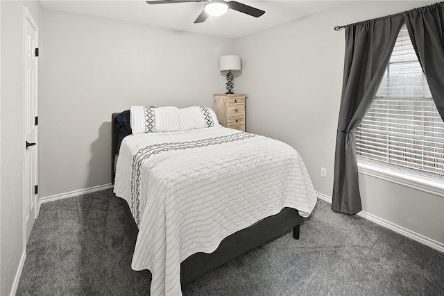 carpeted bedroom featuring multiple windows, baseboards, and a ceiling fan