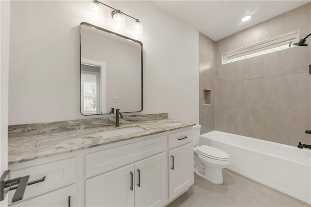 full bathroom with tiled shower / bath, vanity, and toilet