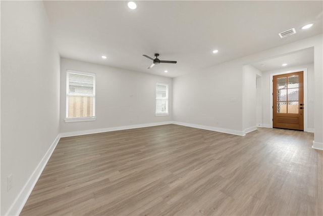 empty room featuring ceiling fan, plenty of natural light, and light hardwood / wood-style floors