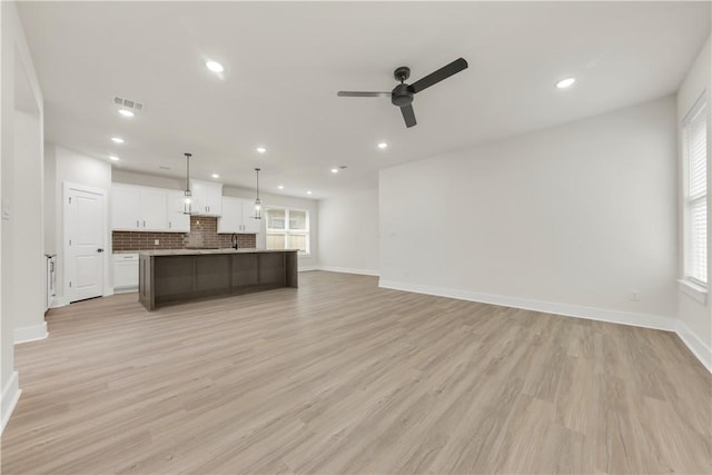 unfurnished living room with ceiling fan and light hardwood / wood-style floors