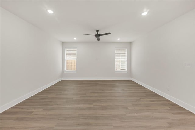 empty room with hardwood / wood-style flooring, ceiling fan, and plenty of natural light