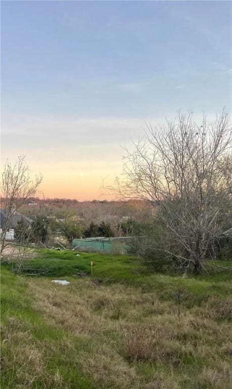 yard at dusk featuring a rural view