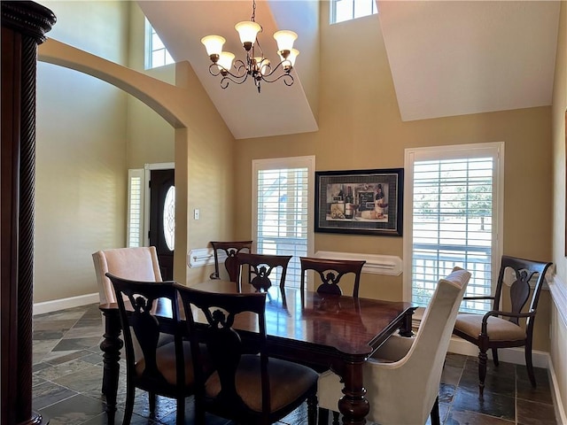 dining area with high vaulted ceiling and a chandelier