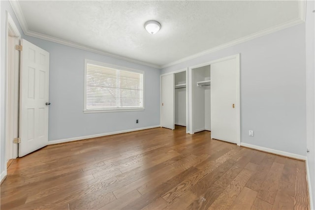 714 S Rosemary Dr, Bryan, TX 77802 - unfurnished bedroom featuring ornamental molding, multiple closets, wood finished floors, and a textured ceiling
